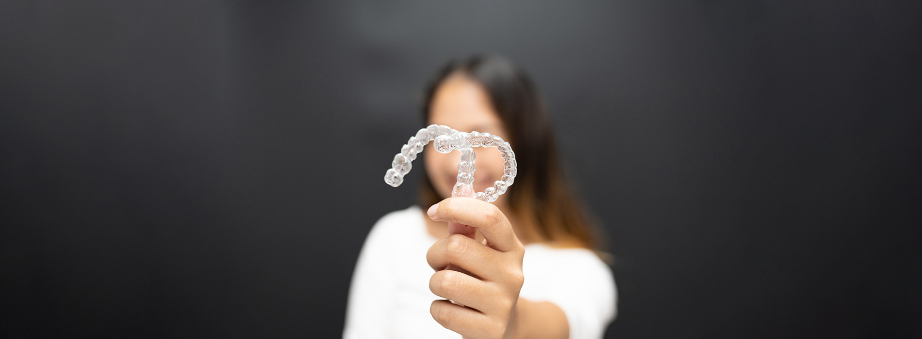 A person holding a toothbrush in front of their face, with the bristles visible.